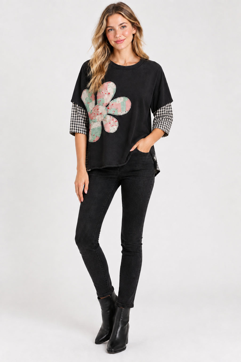 The shirt features a large patchwork flower graphic on the front with pink, green, and beige tones, and has gingham-patterned sleeves.